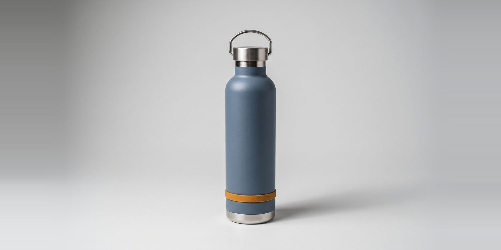 Slate blue insulated water bottle packshot on a grey studio backdrop